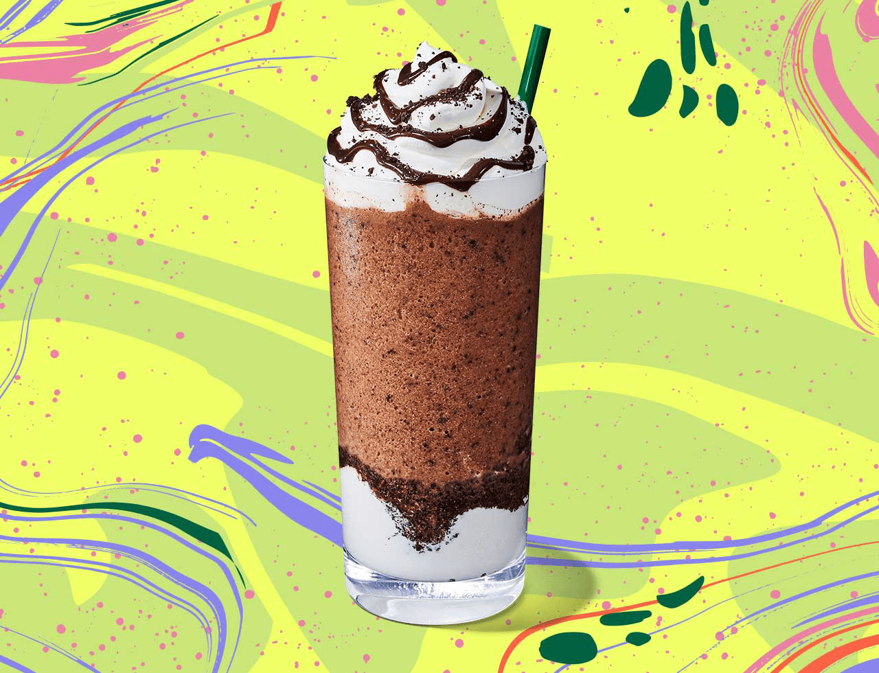 Cold blended coffee drink topped with whipped cream and chocolate drizzle in a tall glass.
