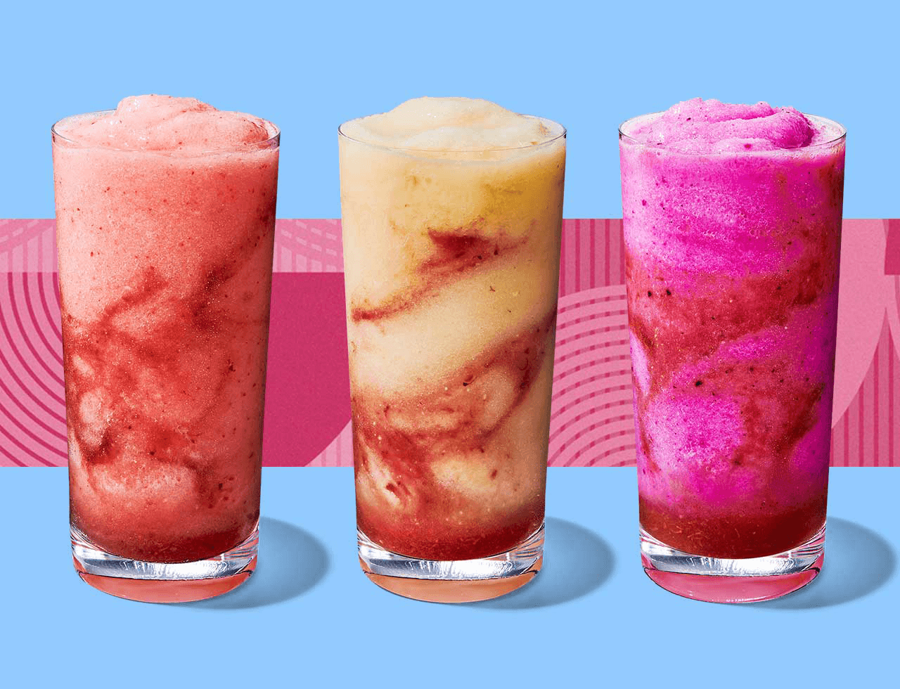 Three frozen blended drinks with colorful swirls in tall glasses.