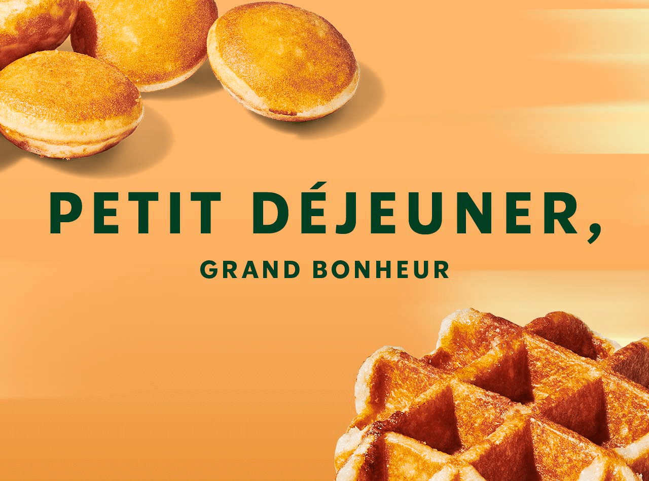 PETIT DÉJEUNER, GRAND BONHEUR| Une assiette en grès avec quatre minicrêpes dorées à la perfection accompagnées d'un gobelet blanc Starbucks rempli d'une boisson espresso, sur un fond jaune avec un soleil levant en arrière-plan.