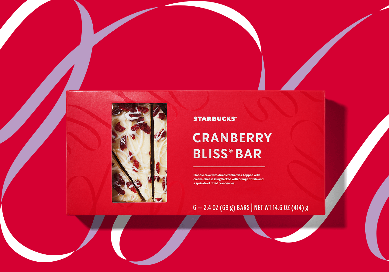 Red box entitled “CRANBERRY BLISS® BAR” with a clear window that shows a dessert bar with cranberries. The background is red with a white-and-lavender ribbon design.