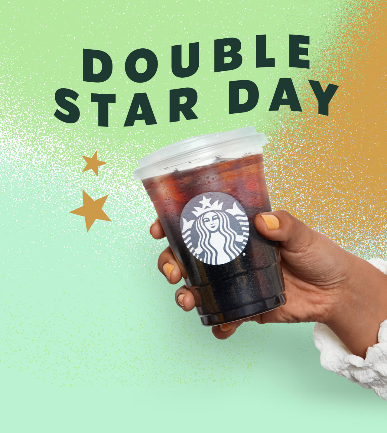 A hand holding an iced coffee in a Starbucks® cold cup with Stars nearby. The background is mint, light green and gold in a textured style similar to paint.